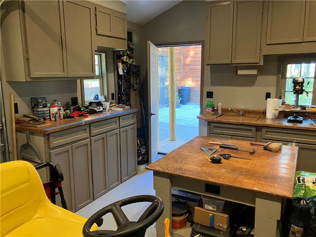 kitchen with gray cabinetry, lofted ceiling, and a healthy amount of sunlight