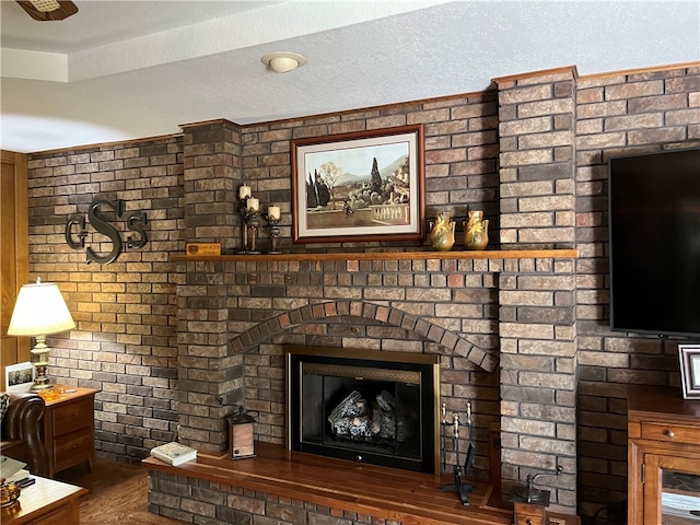 unfurnished living room featuring a textured ceiling, dark hardwood / wood-style flooring, and a brick fireplace