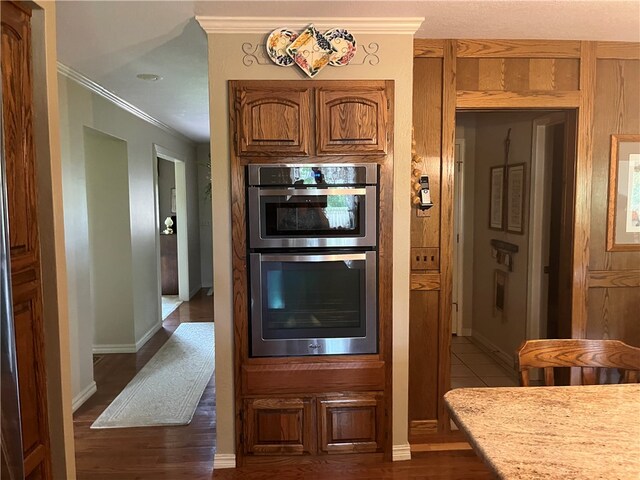 kitchen featuring ornamental molding, double oven, and dark hardwood / wood-style flooring