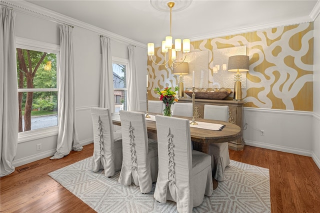 dining space with ornamental molding, a notable chandelier, and hardwood / wood-style floors