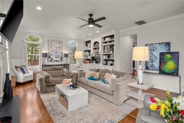 living room featuring ceiling fan, hardwood / wood-style flooring, and crown molding