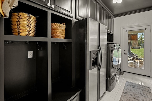 washroom with crown molding, light tile patterned flooring, independent washer and dryer, and cabinets