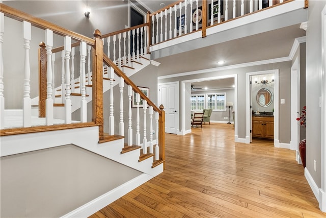 entryway with light hardwood / wood-style floors and ornamental molding