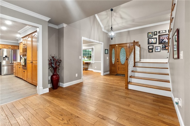 foyer with light wood-type flooring and crown molding