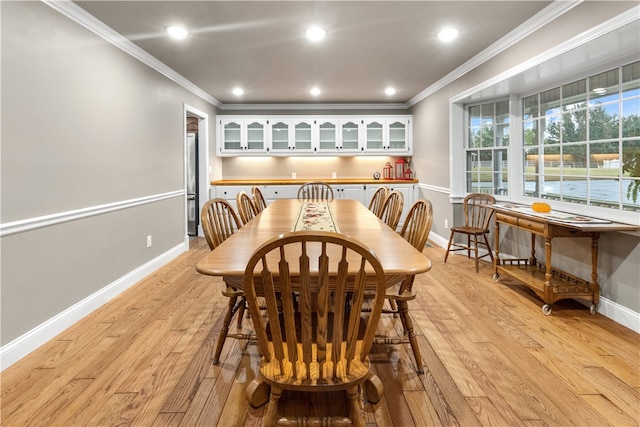 dining space featuring light hardwood / wood-style floors and crown molding