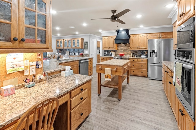 kitchen with stainless steel appliances, tasteful backsplash, light hardwood / wood-style flooring, premium range hood, and ornamental molding