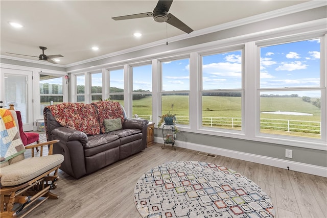 sunroom / solarium with a rural view and ceiling fan