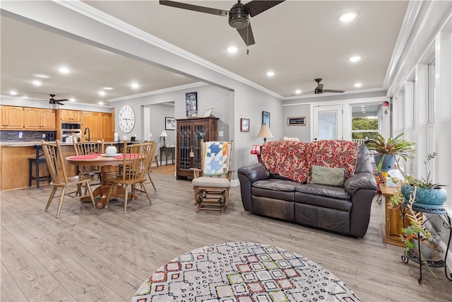 living room with ceiling fan, light wood-type flooring, and ornamental molding