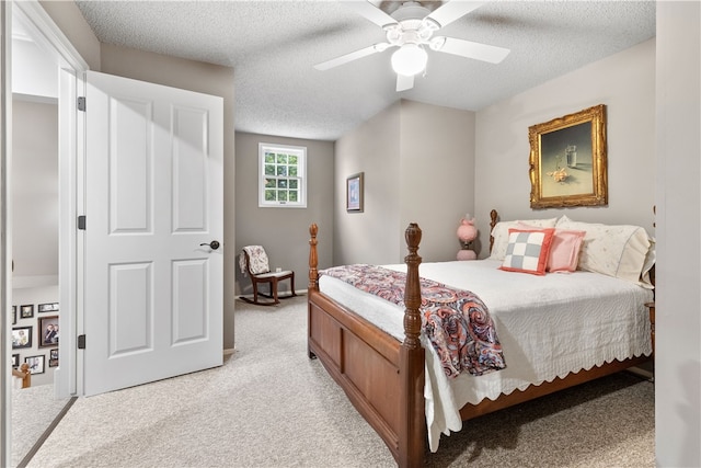 carpeted bedroom featuring ceiling fan and a textured ceiling