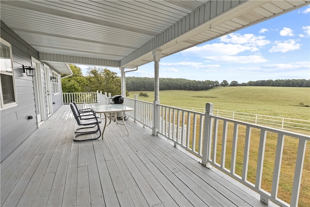 wooden terrace with a yard and a rural view