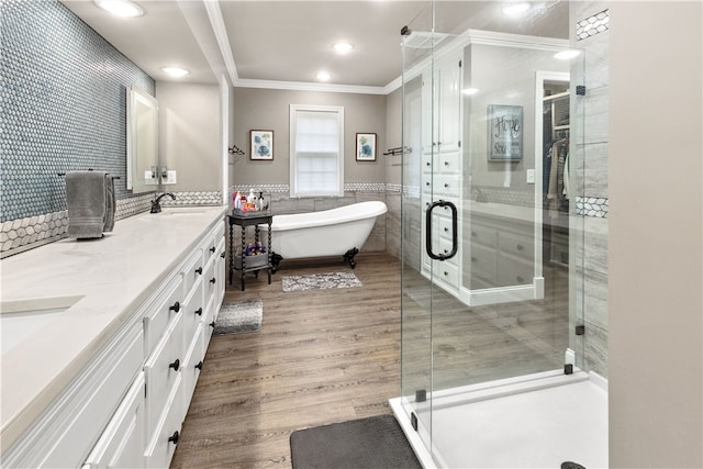 bathroom featuring ornamental molding, vanity, wood-type flooring, tile walls, and plus walk in shower