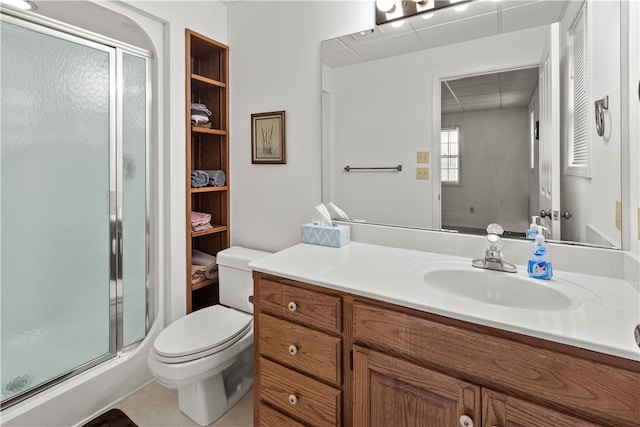 bathroom with tile patterned flooring, vanity, toilet, and a shower with shower door