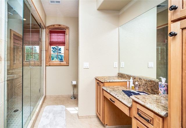 bathroom with tile patterned flooring, an enclosed shower, and vanity