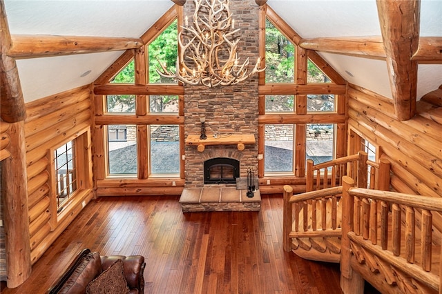 unfurnished living room with a healthy amount of sunlight, dark wood-type flooring, high vaulted ceiling, and a fireplace