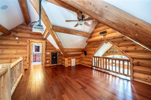 additional living space featuring wine cooler, ceiling fan, hardwood / wood-style flooring, vaulted ceiling with beams, and rustic walls