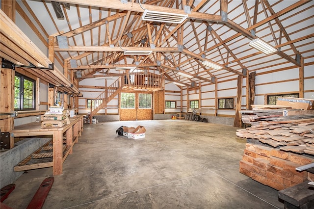 misc room with concrete flooring and high vaulted ceiling