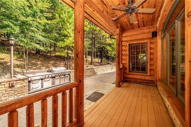 wooden deck featuring ceiling fan, a patio, and exterior kitchen