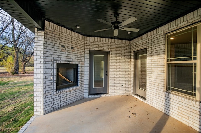 view of patio / terrace with ceiling fan and an outdoor fireplace