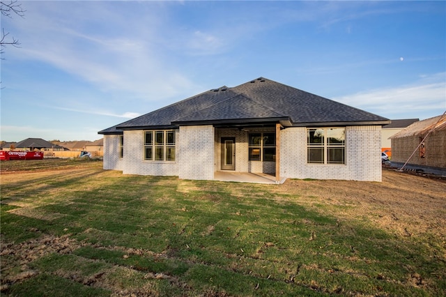 rear view of property featuring a lawn and a patio