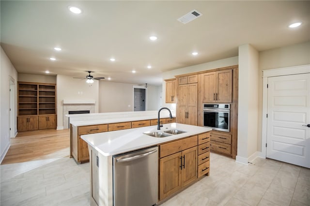 kitchen featuring appliances with stainless steel finishes, sink, ceiling fan, and an island with sink