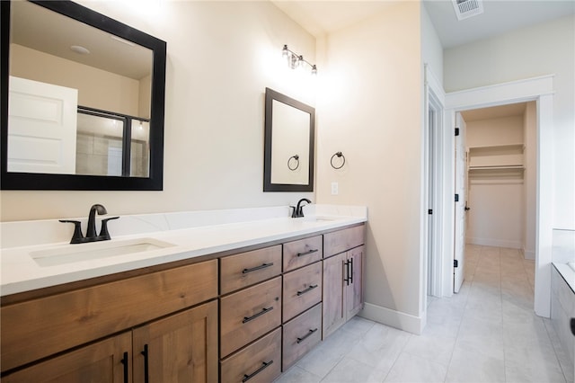 bathroom featuring walk in shower, tile patterned flooring, and vanity