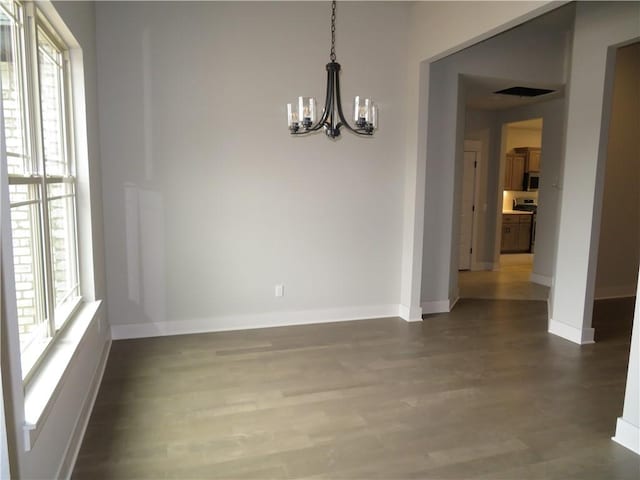 unfurnished dining area with plenty of natural light, baseboards, and wood finished floors