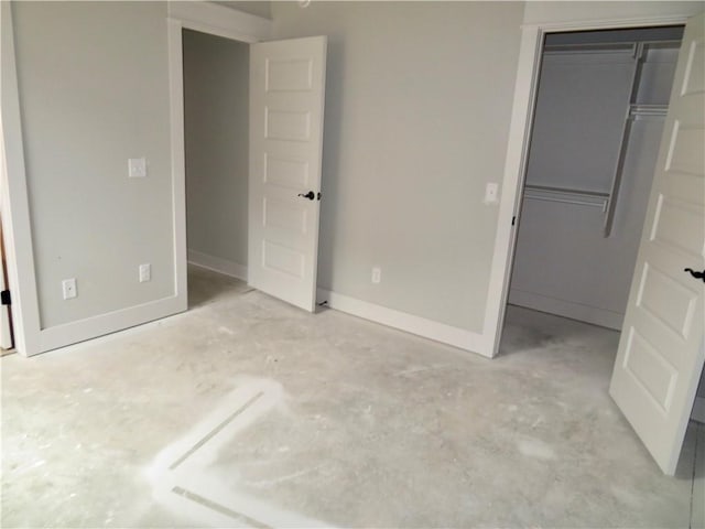 unfurnished bedroom featuring a closet, unfinished concrete floors, and baseboards