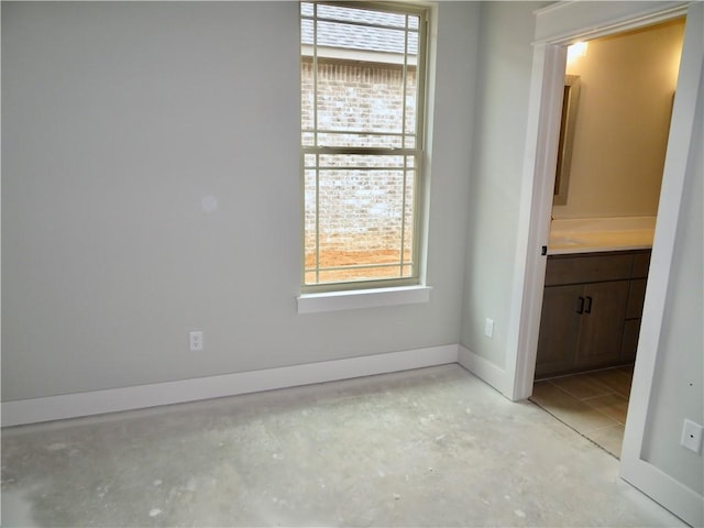 spare room with baseboards and concrete floors