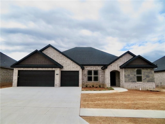 view of front of house featuring brick siding, concrete driveway, an attached garage, and a shingled roof