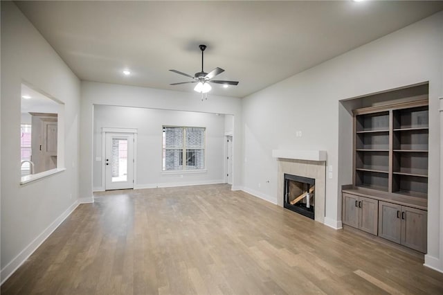 304 Doral Dr, Cave Springs, AR 72718 - unfurnished living room featuring a ceiling fan, wood finished floors, a tile fireplace, baseboards, and recessed lighting