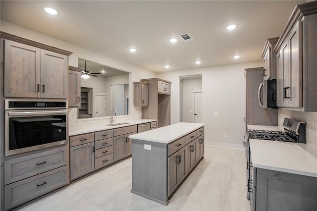 304 Doral Dr, Cave Springs, AR 72718 - kitchen with a center island, a sink, visible vents, light countertops, and appliances with stainless steel finishes