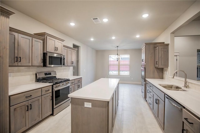 304 Doral Dr, Cave Springs, AR 72718 - kitchen with light countertops, visible vents, a sink, a kitchen island, and appliances with stainless steel finishes