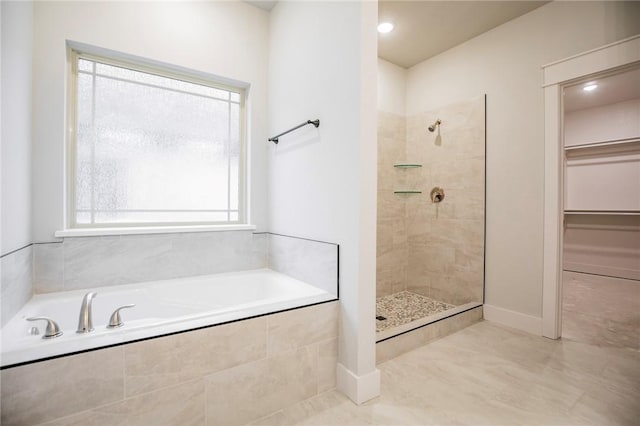 304 Doral Dr, Cave Springs, AR 72718 - bathroom with a tile shower, a bath, a spacious closet, and baseboards