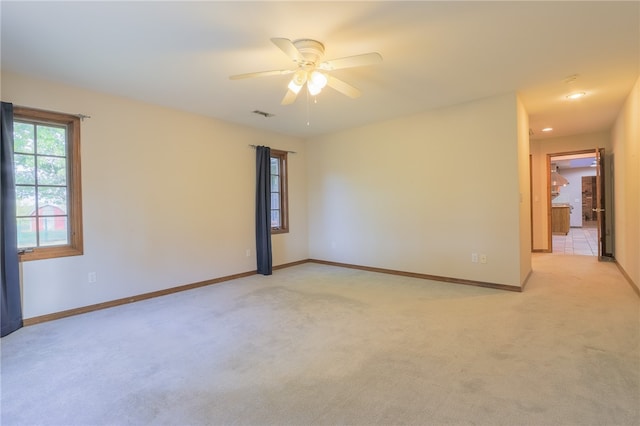 empty room featuring ceiling fan and light colored carpet