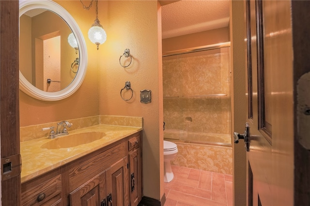 full bathroom featuring tiled shower / bath, vanity, toilet, and a textured ceiling