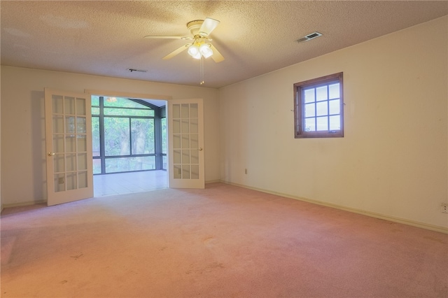 carpeted spare room with ceiling fan, french doors, and plenty of natural light