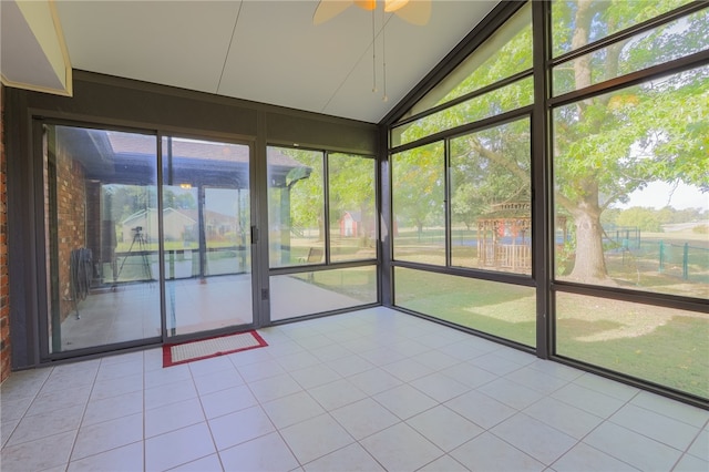 unfurnished sunroom featuring ceiling fan, vaulted ceiling, and a wealth of natural light