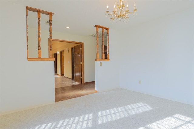 spare room with an inviting chandelier and light wood-type flooring