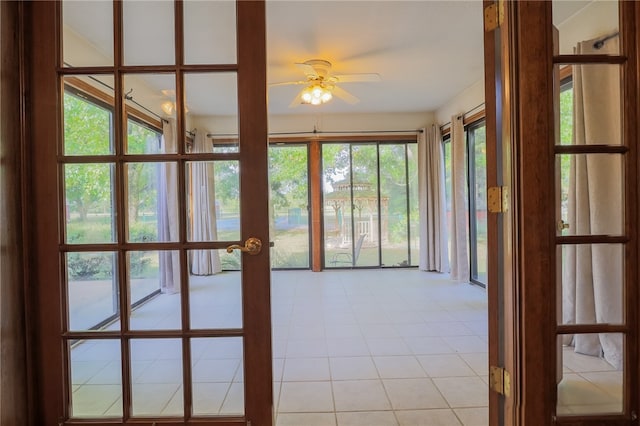 unfurnished sunroom featuring ceiling fan