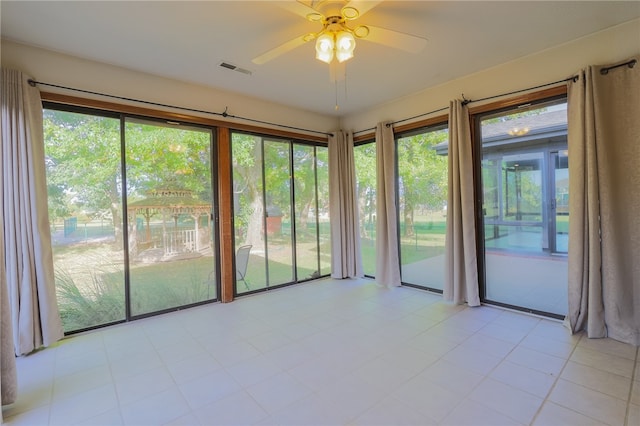 unfurnished room with light tile patterned floors and ceiling fan