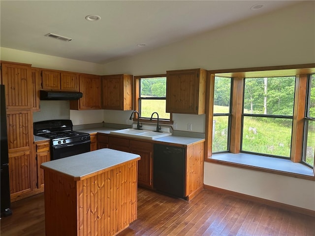 kitchen with a center island, vaulted ceiling, a healthy amount of sunlight, and black appliances