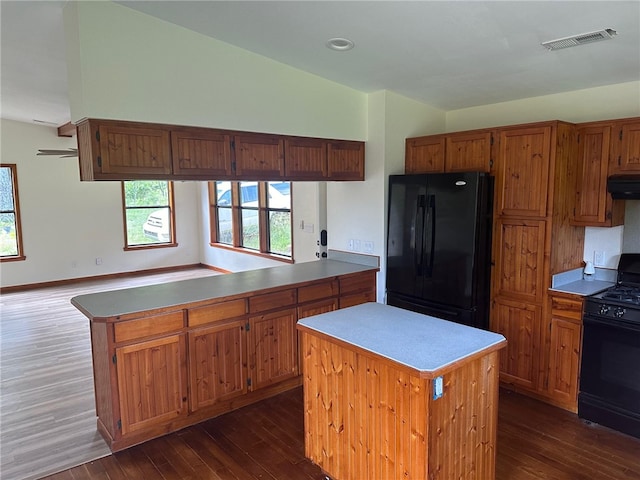 kitchen with a kitchen island, dark hardwood / wood-style floors, kitchen peninsula, and black appliances