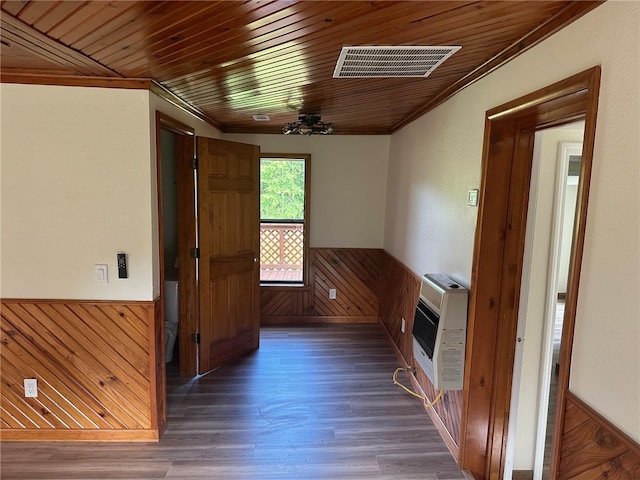 hall with heating unit, wooden walls, wood ceiling, and dark hardwood / wood-style flooring