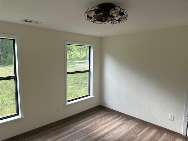 unfurnished room featuring hardwood / wood-style flooring and plenty of natural light