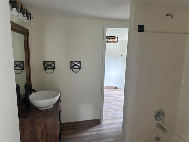 bathroom featuring a textured ceiling, washtub / shower combination, vanity, and hardwood / wood-style floors