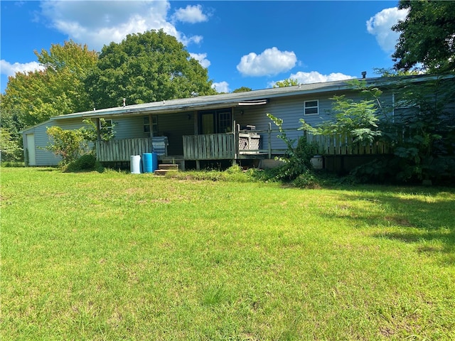 rear view of house featuring a deck and a lawn