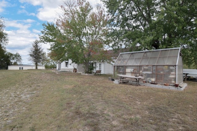 view of yard with an outbuilding and a greenhouse