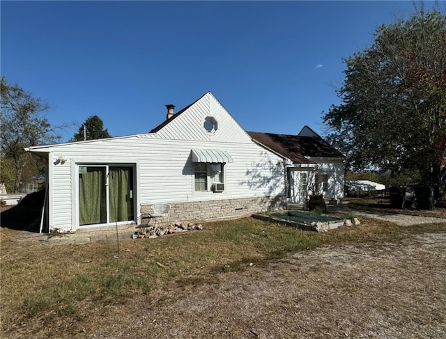 rear view of property featuring cooling unit and a yard