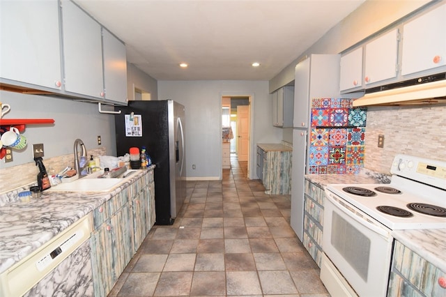 kitchen with light countertops, a sink, under cabinet range hood, white appliances, and decorative backsplash