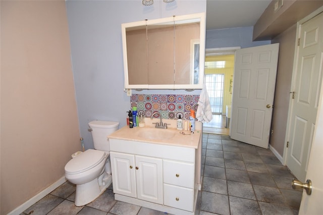 half bathroom with baseboards, toilet, vanity, and tasteful backsplash